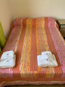 Una cama con dos toallas encima. en La casita en San Rafael