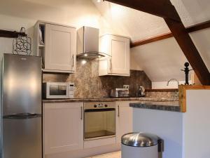 a kitchen with white cabinets and a stainless steel refrigerator at The Manor Wing in Par