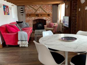 基督城的住宿－The Old Thatch，客厅配有红色的沙发和桌子