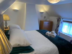 1 dormitorio con 1 cama con toallas en The Old Thatch, en Christchurch