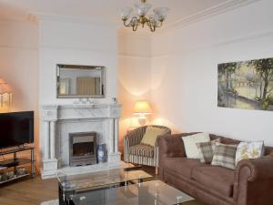 a living room with a couch and a fireplace at Sandfield The Promenade in Southport