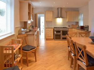 a kitchen with a wooden floor and a table with chairs at Sandfield The Promenade in Southport