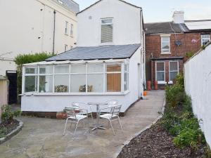 een patio met een tafel en stoelen voor een huis bij Sandfield The Promenade in Southport