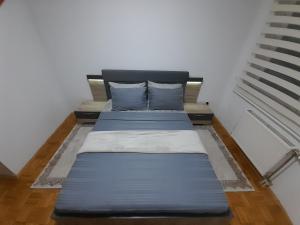 Gray Apartment 1 Pristina في بريشتيني: سريرين في غرفة ذات أغطية ووسائد زرقاء