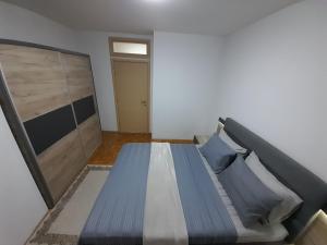 a bedroom with a bed with blue pillows at Gray Apartment 1 Pristina in Prishtinë