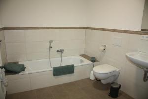 een badkamer met een bad, een toilet en een wastafel bij Ferienwohnung Waldblick - a75529 in Bräunlingen