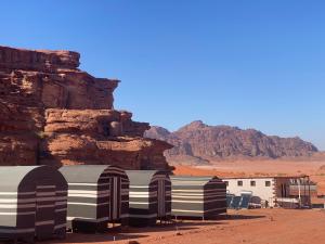 a group of buildings in the desert near a mountain at Walid Bedouin Camp in Wadi Rum