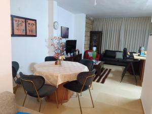 uma sala de estar com uma mesa e cadeiras e um sofá em Enjoy home em Jerusalém