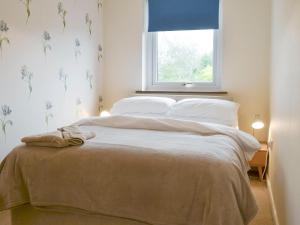 a bedroom with a large bed with a window at Ty Haf in Trearddur