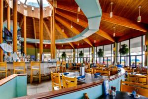um restaurante com uma área de refeições com mesas e cadeiras em Edgewater Golf Villa 2110 em Panama City Beach