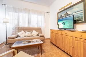 a living room with a couch and a flat screen tv at Benidorm Old Town House - Casa Casco Antiguo in Benidorm
