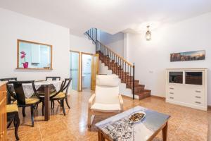 a living room with a table and chairs and a staircase at Benidorm Old Town House - Casa Casco Antiguo in Benidorm