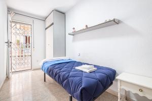 a small bedroom with a blue bed and a window at Benidorm Old Town House - Casa Casco Antiguo in Benidorm