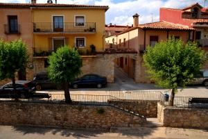 a building with cars parked in a parking lot at Alojamientos Carmen in Beteta