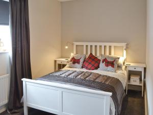 a bedroom with a large white bed with pillows at Peel Post Office Apartment in Peel