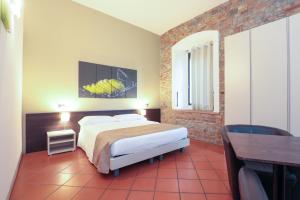una camera con letto, tavolo e scrivania di Villa D&D a Parma
