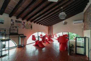 a room with red chairs and tables in it at Villa D&D in Parma