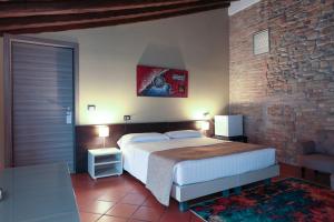 a bedroom with a large bed and a brick wall at Villa D&D in Parma