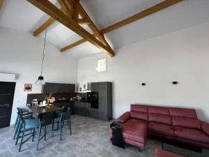 a living room with a red couch and a table at La maurette piscine chauffee in La Motte