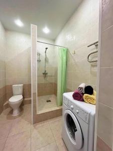 een wasmachine in een badkamer met een douche bij Однокомнатные апартаменты в золотом квадрате ЖК GREEN PLAZA in Aqtau