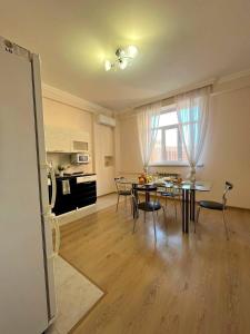 cocina y sala de estar con mesa y sillas en Однокомнатные апартаменты в золотом квадрате ЖК GREEN PLAZA en Aktau