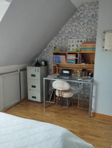 einen Schreibtisch und einen Stuhl in einem Zimmer in der Unterkunft Le jardin aux oiseaux in Saint-Jouan-de-lʼIsle