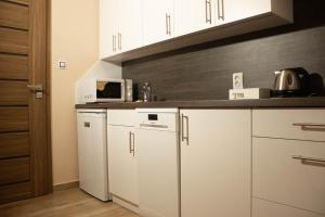 a kitchen with white cabinets and a microwave at Apartmány Pilot in Velká Hleďsebe