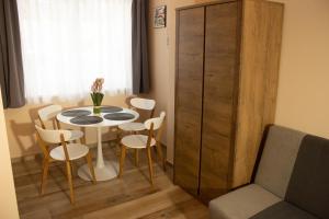a dining room with a table and chairs and a cabinet at Apartmány Pilot in Velká Hleďsebe