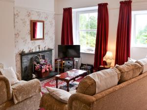 a living room with a couch and a fireplace at Oak Lea in Braithwaite