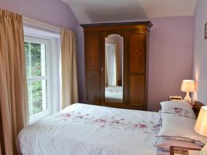 a bedroom with a bed and a large window at Oak Lea in Braithwaite