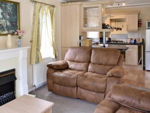 a living room with a couch and a kitchen at Hollys Lodge - E4072 in Brough