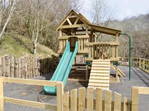 a wooden playground with a slide and a wooden fence at Hollys Lodge - E4072 in Brough