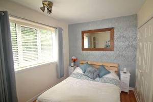 a bedroom with a bed with a mirror on the wall at Boswell-Large Balcony Apartment-Town & Racecourse in Doncaster