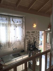 a kitchen with a sink and a window at Alexadras Guesthouse in Ampelochórion