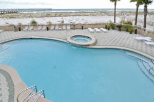 a swimming pool with a beach in the background at Summerwind West in Navarre