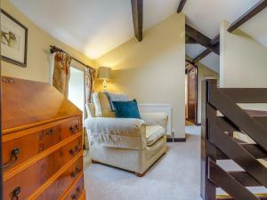 1 dormitorio con vestidor y silla en una habitación en Old Brewery Cottage- Uk3002, en Haltwhistle