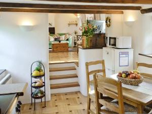 Rock Barn في Saint Issey: مطبخ وغرفة طعام مع طاولة وكراسي