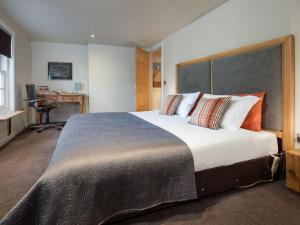 a bedroom with a large bed and a desk at Willow in Gatehouse of Fleet