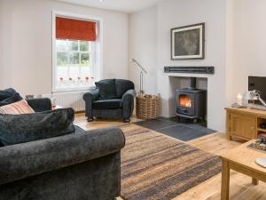 a living room with a couch and a fireplace at Willow in Gatehouse of Fleet