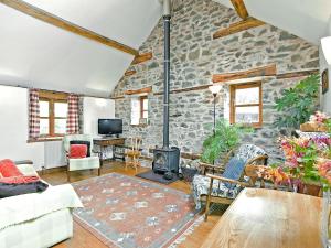 a living room with a stone wall at Llofft Stabal in Llanerfyl