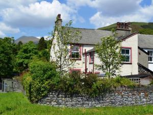 a white house with a stone wall at Two Chimneys in Keswick