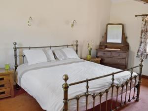 een slaapkamer met een bed, een dressoir en een spiegel bij The Barn in Parkham