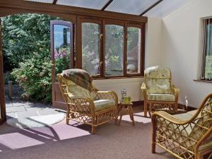 twee stoelen in een kamer met ramen bij The Barn in Parkham