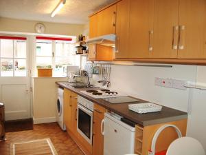 a kitchen with wooden cabinets and a stove top oven at Foxhole in Threlkeld