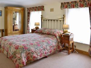 a bedroom with a bed and a table with a night stand at Leatheswater in Thirlmere