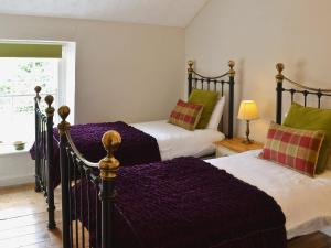 セント・オーステルにあるGewans Farm Cottageのベッドルーム1室(紫のシーツが敷かれたベッド2台、窓付)