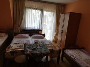 a bedroom with two beds and a table and a window at Kwatera prywatna u Janiny in Biały Dunajec
