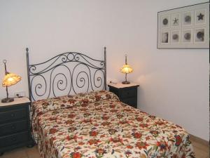 ein Schlafzimmer mit einem Bett mit Blumenbettdecke und zwei Lampen in der Unterkunft Casa Bellissima in Calafat + 14 Fotos