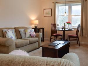 a living room with a couch and a table at 15 Elm Court in Keswick