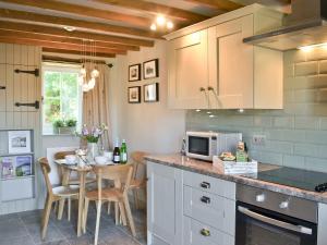 a kitchen with a table and a counter top at Ivy Bush Cottage in Llanddewi-Brefi